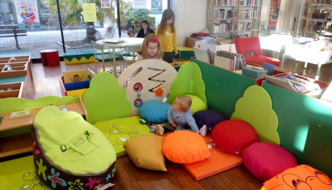 espace des enfants, très coloré. Des coussins de couleurs pour s'asseoir/