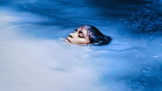 Photographie couleur d'une tête émergeant de l'eau d'une rivière.
