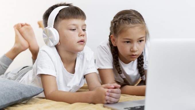 Deux enfants regardant l'écran un ordianteur portable.