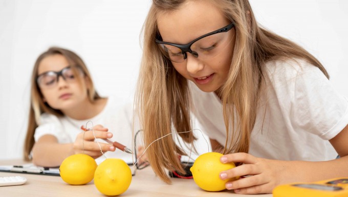 Deux enfants réalisant une expérience scientifique avec des fruits.