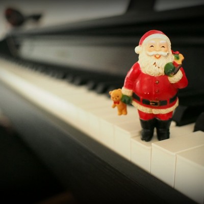Une figurine de Père Noël placée sur un clavier de piano.