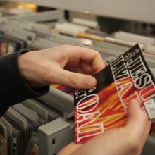 Rayonnage de disques de la Bibliothèque des Champs Libres avec un agent effectuant le rangement de documents.