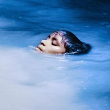 Photographie couleur d'une tête émergeant de l'eau d'une rivière.