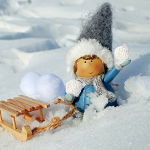 petit personnage trainant une luge dans la neige