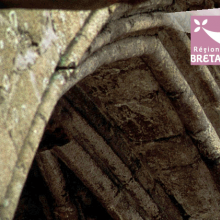 Photo d'une arche d'un monument, et logo de la Région Bretagne